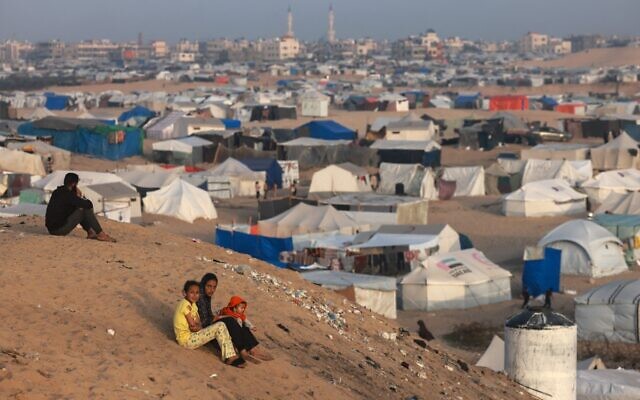 Palestinian children sit on a hill next to tents housing the displaced in Rafah in the southern Gaza Strip on March 30, 2024. (Mohammed Abed/AFP)