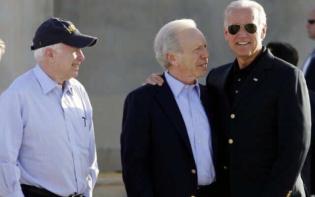 US Sen. John McCain, left, looks on as Sen. Joe Lieberman, center, and US Vice President Joe Biden, right, share a light moment after Biden's arrival in Baghdad, Iraq, Saturday, July 3, 2010. (AP Photo/Hadi Mizban)