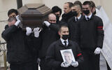 Workers carry the coffin and a portrait of Russian opposition leader Alexei Navalny out of the Church of the Icon of the Mother of God Soothe My Sorrows, in Moscow, Russia, Friday, March 1, 2024. (AP Photo)