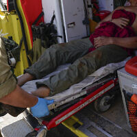 Israeli security forces in Kiryat Shoma evacuate a wounded Thai man after he was hit by an anti-tank missile fired from Lebanon, March 4, 2024. (AP Photo/Ariel Schalit)