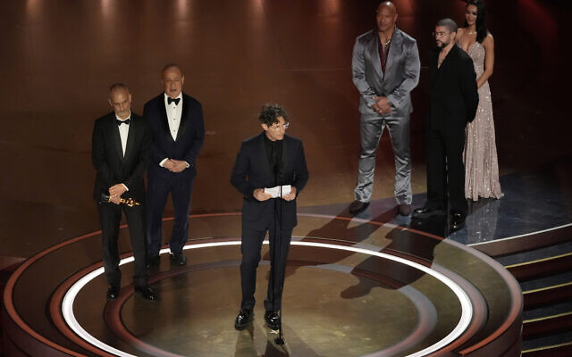 James Wilson, from left, Leonard Blavatnik, and Jonathan Glazer accept the award for 'The Zone of Interest' from the United Kingdom, for best international feature film while Dwayne Johnson and Bad Bunny look on, during the Oscars on March 10, 2024, at the Dolby Theatre in Los Angeles. (AP Photo/Chris Pizzello)