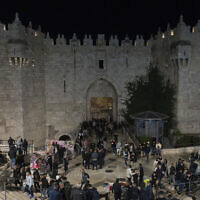 Illustrative: People walk in front of Damascus Gate in the Old City of Jerusalem, on the first day of Ramadan, March 11, 2024. (AP Photo/Ohad Zwigenberg)