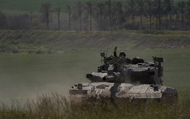 Israeli soldiers move on the top of a tank near the Israeli-Gaza border, as seen from southern Israel, Wednesday, March 20, 2024. (AP Photo/Leo Correa)