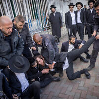 Ultra-Orthodox men clash with police during a protest outside an army recruitment office in Jerusalem, March 4, 2024. (Chaim Goldberg/Flash90)