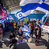 Activists protest outside the UNRWA office in Jerusalem on March 20, 2024. (Yonatan Sindel/Flash90)