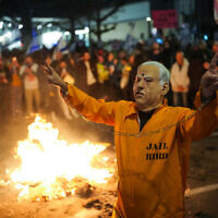 An anti-government demonstrator wearing a costume of Prime Minister Benjamin Netanyahu in a prison jumpsuit   protests outside the IDF's Kirya military headquarters in Tel Aviv on March 23, 2024. (Erik Marmor/Flash90)