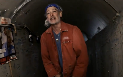 American Jewish rapper Matisyahu in the mock Hamas tunnel at Tel Aviv's Hostages Square, in a still image from the music video for his new song 'Ascent,' released March 29, 2024. Hostage Amiram Cooper, 84, of Kibbutz Nir Oz, is pictured to the singer's left. (Screen capture: Youtube/Matisyahu, used in accordance with Clause 27a of the Copyright Law)