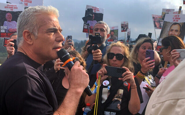 Opposition leader Yair Lapid speaks at the 'unity march' from Re'im to Jerusalem on March 2, 2024. (Charlie Summers/Times of Israel)