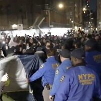 A screenshot of video throwing a Palestinian demonstrator throwing chair toward NYPD officers, as they move to disperse an anti-Israel "liberated zone" set up at New York University, April 22, 2024. (X video screenshot; used in accordance with Clause 27a of the Copyright Law)