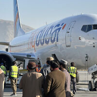 Illustrative: People stand on the tarmac next to a Flydubai airline after it landed at Kabul International Airport in Kabul on November 15, 2023. (AFP)