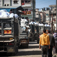 Trucks carrying humanitarian aid make their way along a street in Rafah in the southern Gaza Strip, on March 10, 2024. (MOHAMMED ABED / AFP)
