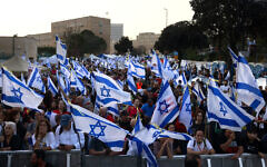 Anti-government protesters wave flags at a four-day sit-in near the Knesset in Jerusalem on April 1, 2024 (Menahem Kahana / AFP)