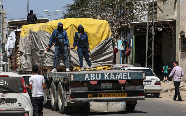 Masked members of the so-called 'People's Protection Committees' guard a humanitarian aid truck in Rafah in the southern Gaza Strip on April 3, 2024. (Said Khatib / AFP)