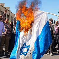 Demonstrators burn an Israeli flag during the funeral for seven Islamic Revolutionary Guard Corps members killed in a strike in Syria, which Iran blamed on Israel, in Tehran on April 5, 2024.  (Photo by ATTA KENARE / AFP)