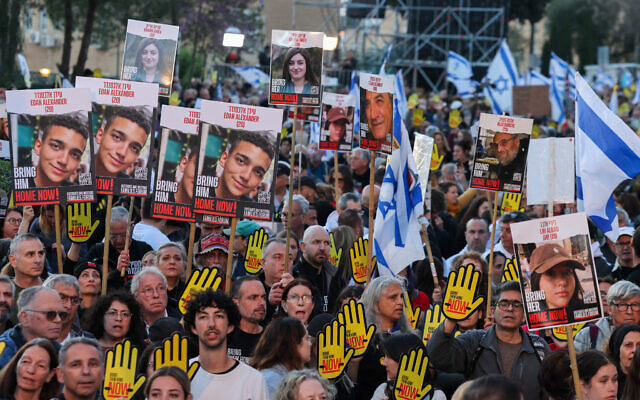 Relatives and supporters of hostages held in Gaza since Hamas's October 7 massacre hold placards and wave national flags during a demonstration in front of the Knesset in Jerusalem on April 7, 2024. (Menahem Kahana/AFP)