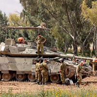 Israeli soldiers gather around army tanks stationed in an area along the border with the Gaza Strip in southern Israel on April 10, 2024. (Jack Guez / AFP)