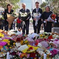 Australian Prime Minister Anthony Albanese (C) stands with New South Wales Premier Chris Minns (4th R) and other officials as they prepare to leave flowers outside the Westfield Bondi Junction shopping mall in Sydney on April 14, 2024. (DAVID GRAY / AFP)