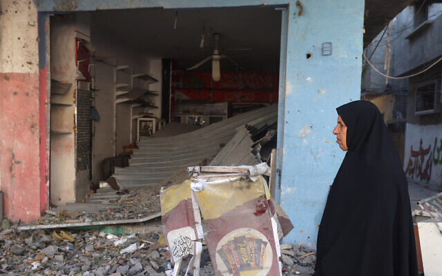 A Palestinian woman walks past a building heavily damaged by Israeli strike the previous night in Rafah the southern Gaza Strip on April 17, 2024 (Photo by MOHAMMED ABED / AFP)