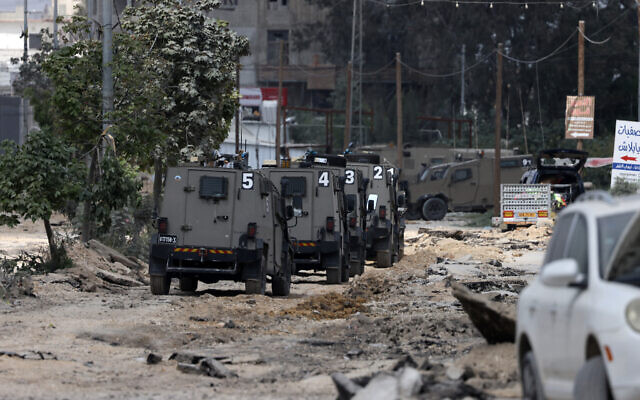 Israeli military vehicles drive along a devastated street in the Nur Shams refugee camp in the West Bank, during a raid on April 19, 2024. (Jaafar Ashtiyeh/AFP)