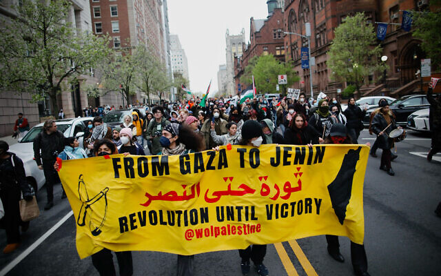 Pro-Palestinian, anti-Israel protesters carry a sign implying a desire to eradicate the Jewish state during a march against Israel outside Columbia University in New York City on April 18, 2024. (Kena Betancur/AFP)