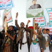 File: Yemenis lift placards and Palestinian flags as they march in the Houthi-run capital Sana'a on April 19, 2024. (Mohammed Huwais/AFP)