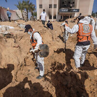 Palestinian health workers dig for bodies buried at Nasser Hospital compound in Khan Younis in the southern Gaza Strip on April 21, 2024. (AFP)