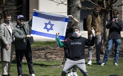 An anti-Israel protester gives the finger in front of counter-demonstrators holding an Israeli flag outside the Gaza Solidarity Encampment on the campus of Northwestern University on April 25, 2024 in Evanston, Illinois. (Scott Olson/Getty Images/AFP)