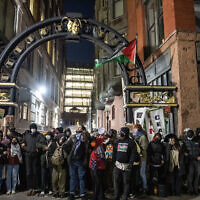 Pro-Palestinian, anti-Israel activists and students from Emerson College block an alley where they have set up an encampment as police move in to clear it, in Boston, Massachusetts, on April 25, 2024. (Joseph Prezioso / AFP)