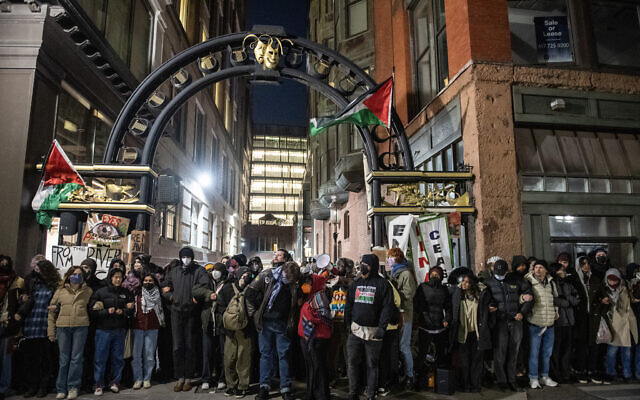 Pro-Palestinian, anti-Israel activists and students from Emerson College block an alley where they have set up an encampment as police move in to clear it, in Boston, Massachusetts, on April 25, 2024. (Joseph Prezioso / AFP)