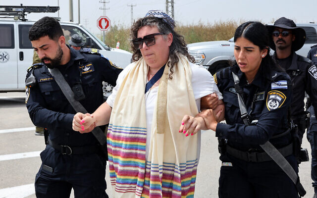 Israeli police officers arrest a member of the group 'Rabbis for Ceasefire' during their march toward the Erez crossing on the border with northern Gaza Strip on April 26, 2024. (Jack Guez/AFP)