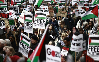 Pro-Palestinian supporters hold placards and wave Palestinian flags during a demonstration against Israel outside Westminster Palace in central London, on April 27, 2024. (Benjamin Cremel/AFP)