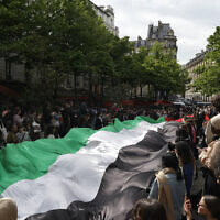 Students display a giant Palestinian flag as they take part in a rally in support of Palestinians and against Israel, at the Sorbonne University in Paris on April 29, 2024. (Geoffroy Van Der Hasselt/AFP)