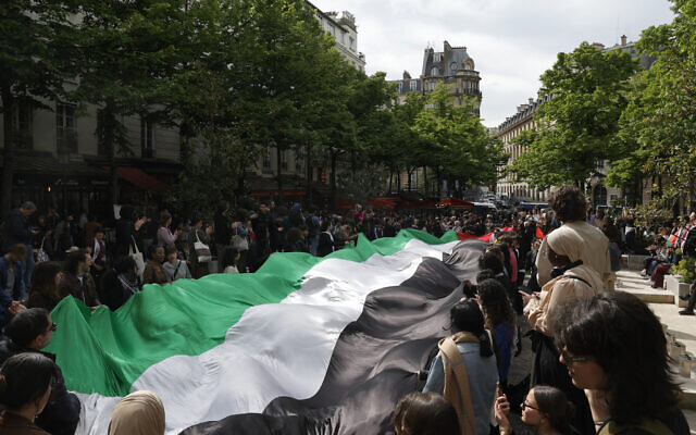 Students display a giant Palestinian flag as they take part in a rally in support of Palestinians and against Israel, at the Sorbonne University in Paris on April 29, 2024. (Geoffroy Van Der Hasselt/AFP)