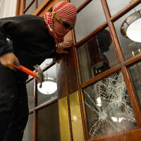 A demonstrator breaks the windows of the front door of Hamilton Hall at Columbia University in order to secure a chain around it to prevent authorities from entering on Tuesday, April 30, 2024 in New York City. (Alex Kent/Getty Images/AFP)