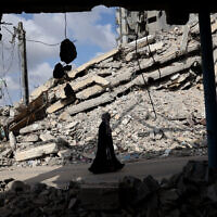 A Palestinian woman walks past the rubble of buildings in Rafah, in the southern Gaza Strip, on April 30, 2024. (AFP)