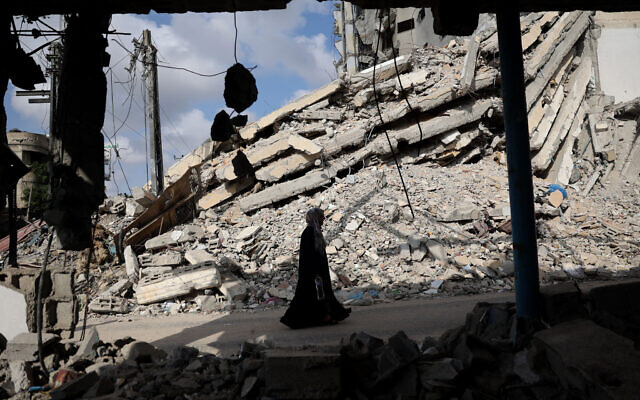 A Palestinian woman walks past the rubble of buildings in Rafah, in the southern Gaza Strip, on April 30, 2024. (AFP)