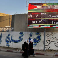 FILE - In this file photo from November 2012, Palestinian school girls pass a billboard covered by Palestinian and Iranian flags with Arabic that reads, "thanks and gratitude to Iran," in Gaza City. (AP Photo/Adel Hana, File)