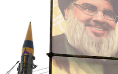 Illustrative: An Iranian domestically built missile is displayed in front of the portrait of the Lebanese Hezbollah leader Sayyed Hassan Nasrallah during a rally of Iran's Basij paramilitary force in support of the Palestinians in Tehran, Iran, November 24, 2023. (AP Photo/Vahid Salemi)