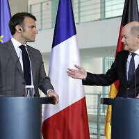 German Chancellor Olaf Scholz (R) talking to French President Emmanuel Macron at a press conference in Berlin, Germany, March 15, 2024. (AP Photo/Ebrahim Noroozi)