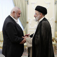 In this photo released by the Iranian Presidency Office, Iranian President Ebrahim Raisi, right, shakes hands with Hamas chief Ismail Haniyeh at his office in Tehran, Iran, March 27, 2024. (Iranian Presidency Office via AP)