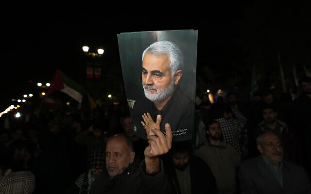 A demonstrator holds up a poster of the late IRGC Quds Force Gen. Qassem Soleimani, who was killed in a U.S. drone attack in 2020 in Iraq, during an anti-Israeli gathering in front of the British Embassy in Tehran, Iran, early April 14, 2024. The demonstration was held as Iran launched its first direct military attack against Israel.  (AP Photo/Vahid Salemi)