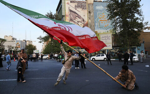 Demonstrators wave a huge Iranian flag in Tehran, Iran, Monday, April 15, 2024. (AP/Vahid Salemi)