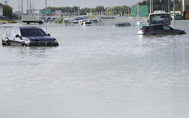Vehicles sit abandoned in floodwater covering a major road in Dubai, United Arab Emirates, Wednesday, April 17, 2024.  (AP Photo/Jon Gambrell)