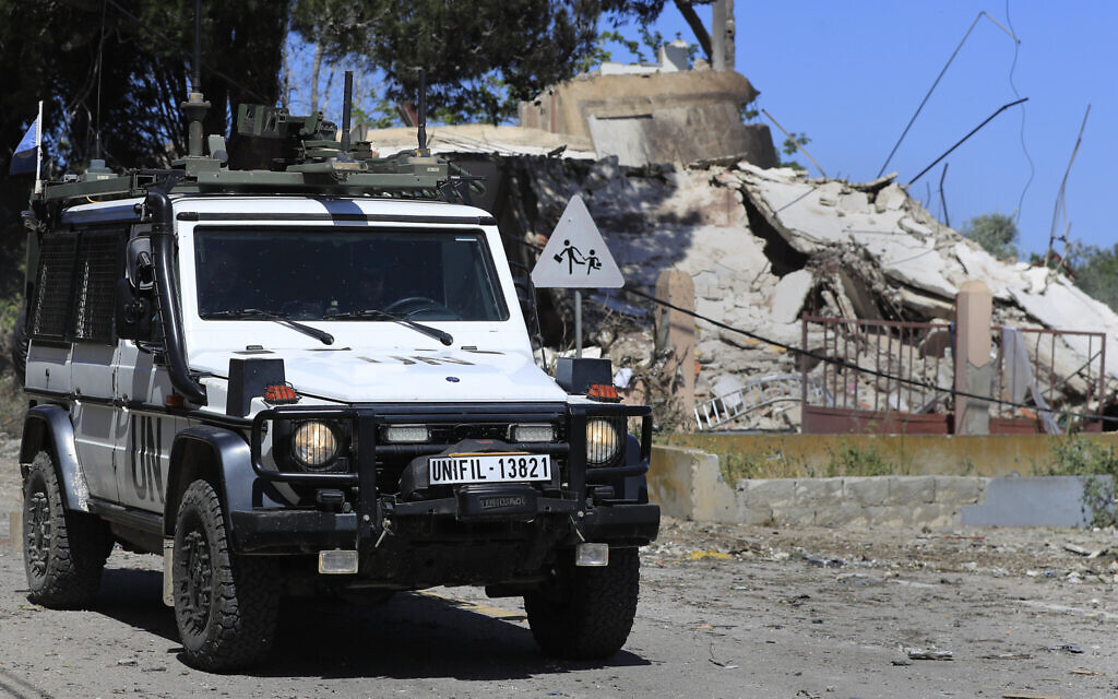 A vehicle of the United Nations peacekeeping forces, moves past a destroyed house that was hit by an Israeli airstrike, in Alma al-Shaab, a Lebanese border village with Israel, south Lebanon, Wednesday, April 17, 2024. (AP Photo/Mohammed Zaatari)