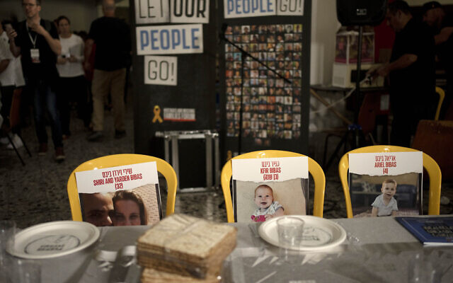 Chairs for the Bibas family, hostages held in Gaza, are seen at a Passover seder table set, Thursday, April 11, 2024, at the communal dining hall at Kibbutz Nir Oz in southern Israel, where a quarter of all residents were killed or captured by Hamas on Oct. 7, 2023. (AP Photo/Maya Alleruzzo, File)