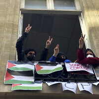 Peo-Palestinian students blocking the Sciences Po University flash the V sign, April 26, 2024 in Paris, France. (AP Photo/Jeffrey Schaeffer)