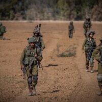 Israeli soldiers from the Netzah Yehuda Battalion patrol near the Israeli-Gaza border, October 20, 2023. (Yonatan Sindel/ Flash90)