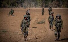 File - Israeli soldiers from the Netzah Yehuda Battalion patrol near the Israel-Gaza border, October 20, 2023. (Yonatan Sindel/ Flash90)