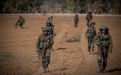 Israeli soldiers from the Netzah Yehuda Battalion patrol near the Israel-Gaza border, October 20, 2023. (Yonatan Sindel/ Flash90)