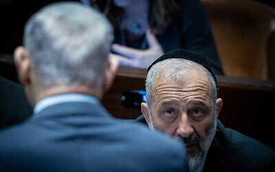 Knesset Member Aryeh Deri looks at Prime Minister Benjamin Netanyahu during a vote on the state budget at the Knesset in Jerusalem, March 13, 2024. (Yonatan Sindel/Flash90)